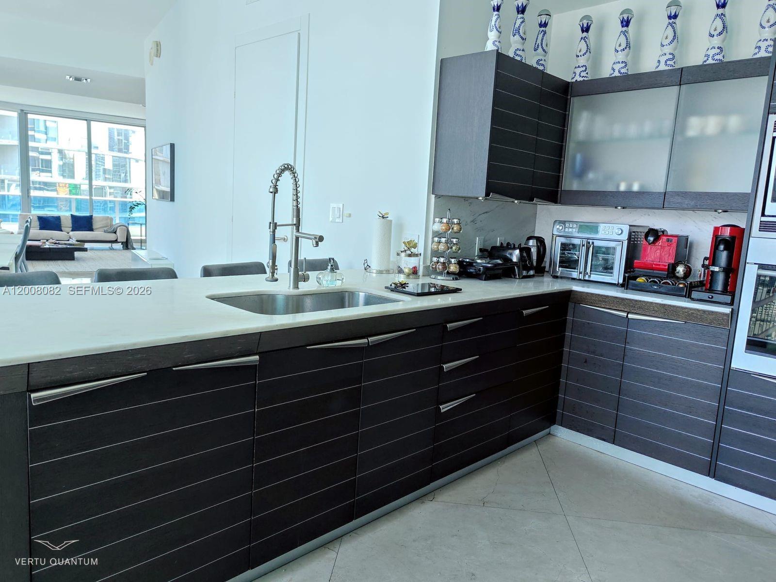 200 Biscayne Blvd Way, Unit 5001 Miami, FL 33131 - Photo 11 of 53 a kitchen with a sink and cabinets