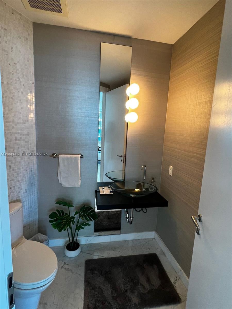 200 Biscayne Blvd Way, Unit 5001 Miami, FL 33131 - Photo 28 of 53 a bathroom with a sink and a mirror with toilet