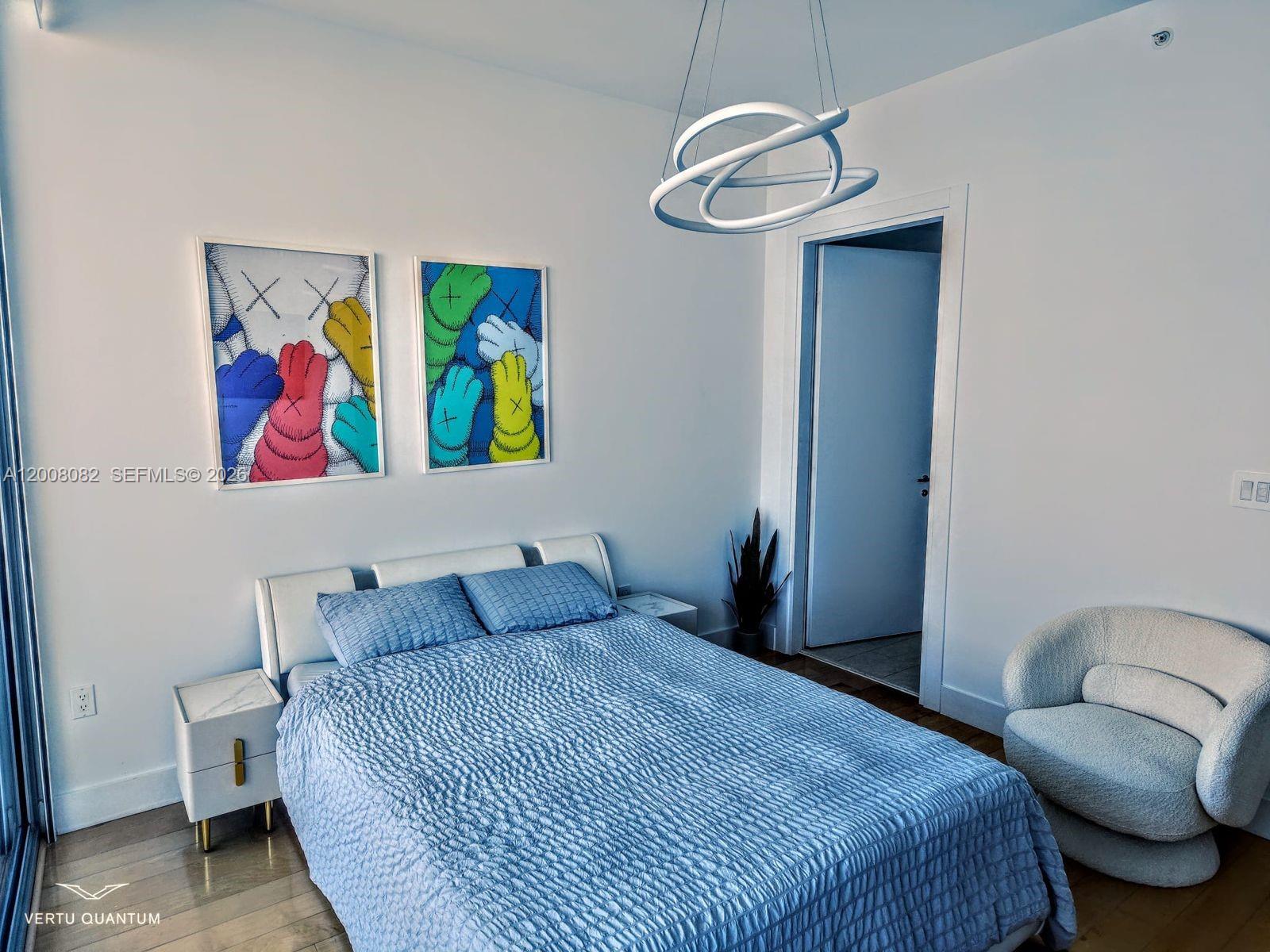 200 Biscayne Blvd Way, Unit 5001 Miami, FL 33131 - Photo 35 of 53 a bedroom with a bed and painting on the wall