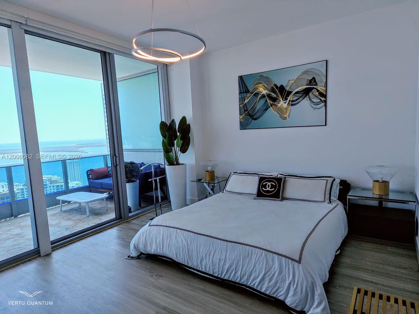 200 Biscayne Blvd Way, Unit 5001 Miami, FL 33131 - Photo 38 of 53 a bedroom with a bed and a chandelier