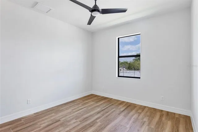 an empty room with a window and wooden floor