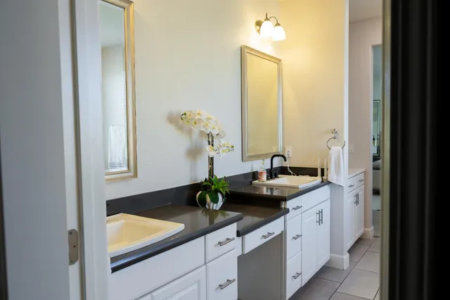 a bathroom with a granite countertop sink and a mirror