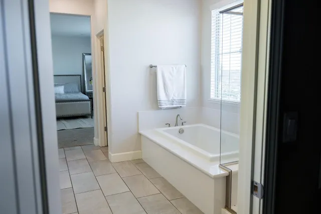 a spacious bathroom with a tub shower and a sink