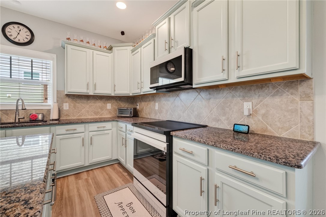 5129 Carson Allen Road Hope Mills, NC 28348 - Photo 11 of 50 a kitchen with granite countertop white cabinets stainless steel appliances and a sink
