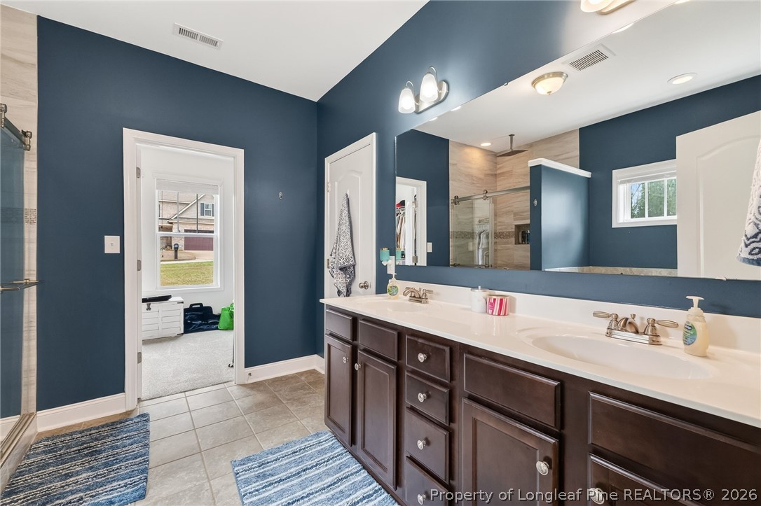 5129 Carson Allen Road Hope Mills, NC 28348 - Photo 20 of 50 a spacious bathroom with a double vanity sink and a mirror