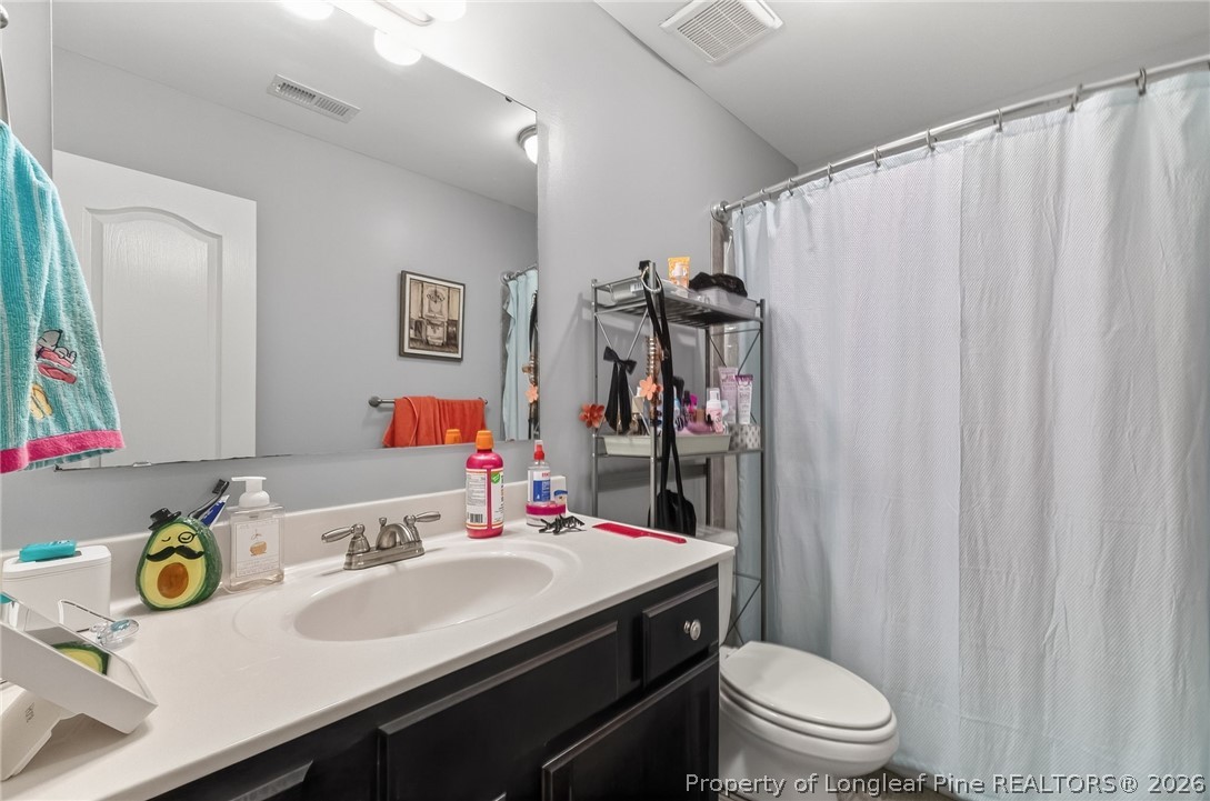 5129 Carson Allen Road Hope Mills, NC 28348 - Photo 23 of 50 a bathroom with a sink vanity mirror and toilet