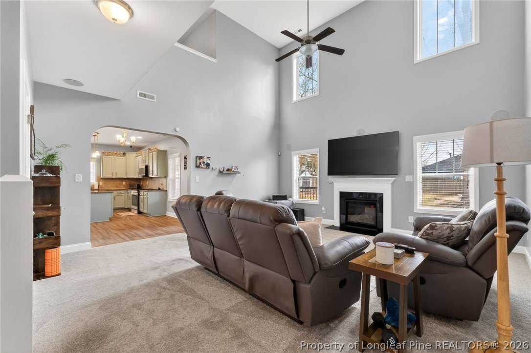 5129 Carson Allen Road Hope Mills, NC 28348 - Photo 3 of 50 a living room with furniture a fireplace and a flat screen tv