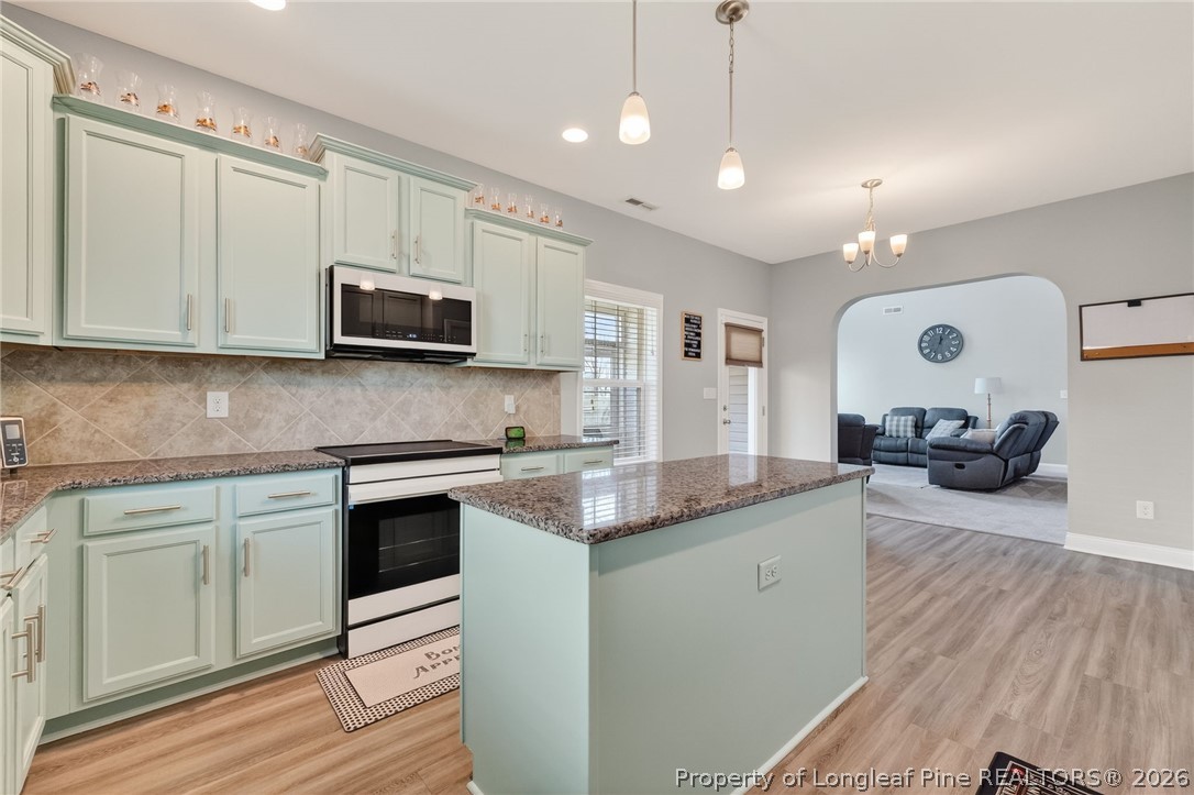 5129 Carson Allen Road Hope Mills, NC 28348 - Photo 7 of 50 a kitchen with kitchen island granite countertop a sink cabinets and wooden floor