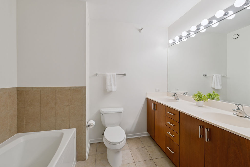 807 Davis Street, Unit 1907 Evanston, IL 60201 - Photo 11 of 20 a spacious bathroom with a granite countertop sink a toilet a mirror and bathtub