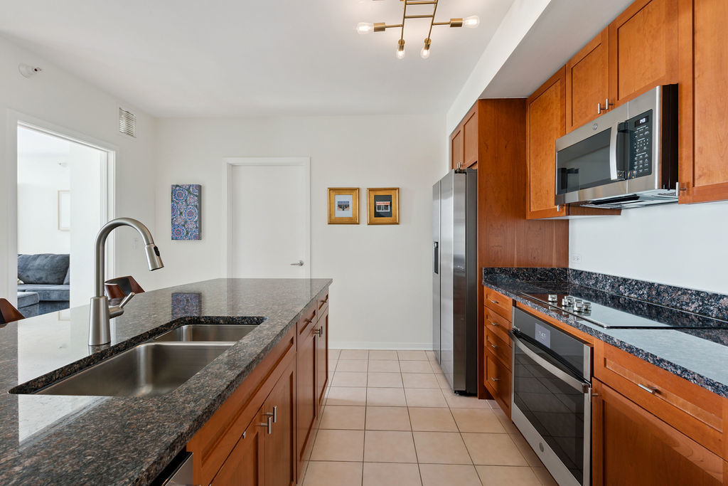 807 Davis Street, Unit 1907 Evanston, IL 60201 - Photo 8 of 20 a kitchen with stainless steel appliances granite countertop a sink and a stove