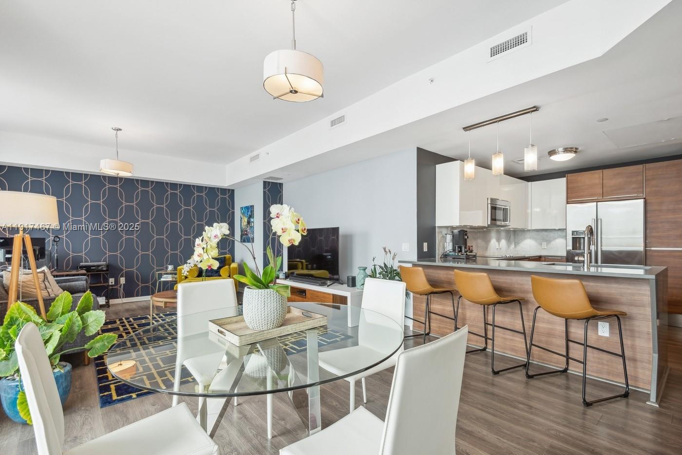 601 Northeast 27th Street, Unit 1406 Miami, FL 33137 - Photo 6 of 13 a living room with kitchen island furniture and a chandelier