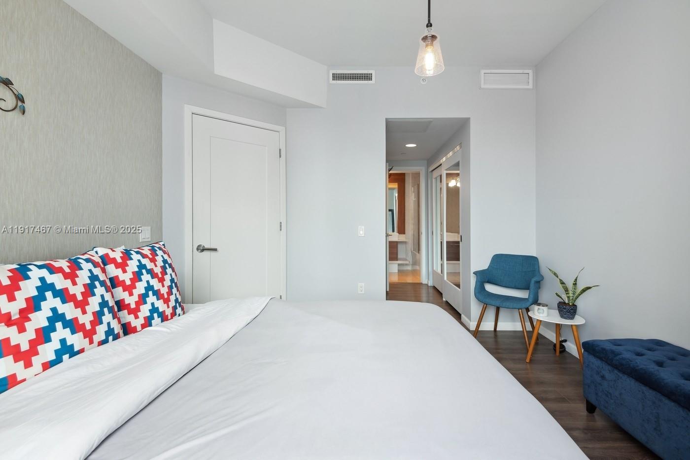 601 Northeast 27th Street, Unit 1406 Miami, FL 33137 - Photo 9 of 13 a bedroom with furniture and a chair