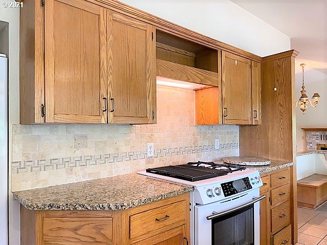 726 North Shepherd Road Washougal, WA 98671 - Photo 22 of 26 a kitchen with granite countertop a stove a sink dishwasher and white cabinets with wooden floor