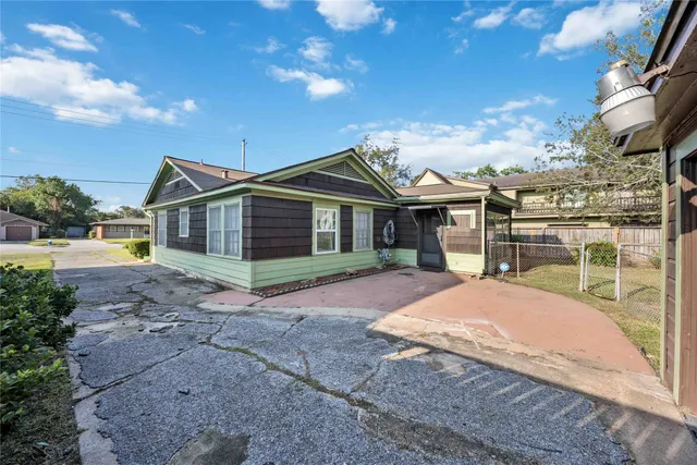 a front view of a house with a yard and potted plants