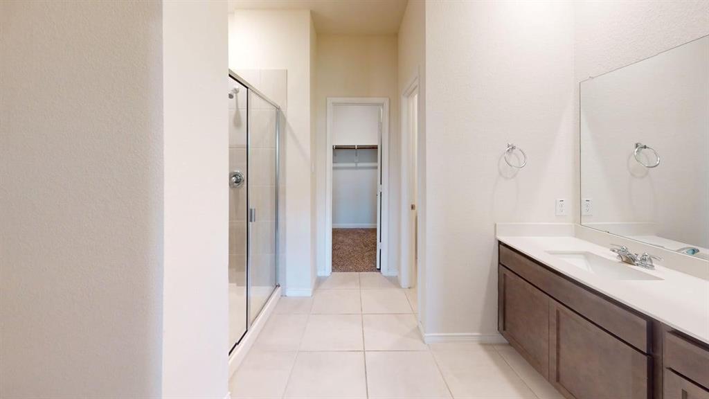 1306 Colonial Bluff Lane Princeton, TX 75407 - Photo 19 of 27 Bathroom with tiled flooring, a glass-enclosed shower, and a wood-finish vanity with an integrated sink and large mirror