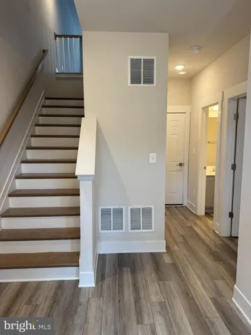 a view of a hallway with wooden floor and entryway