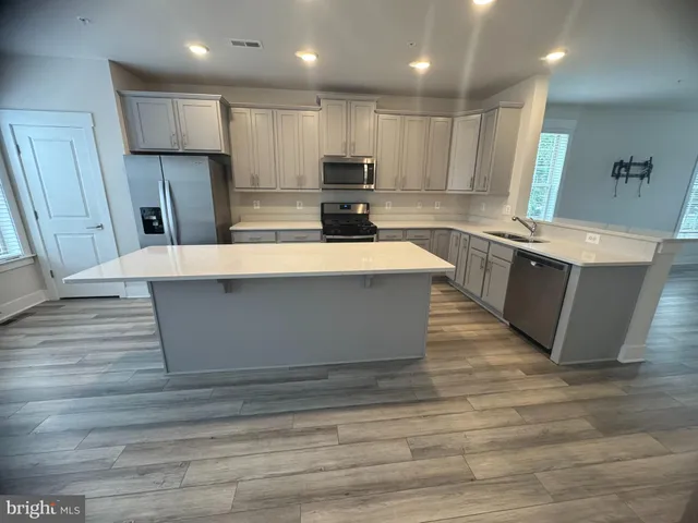 a large kitchen with stainless steel appliances granite countertop a stove a refrigerator a sink and a oven