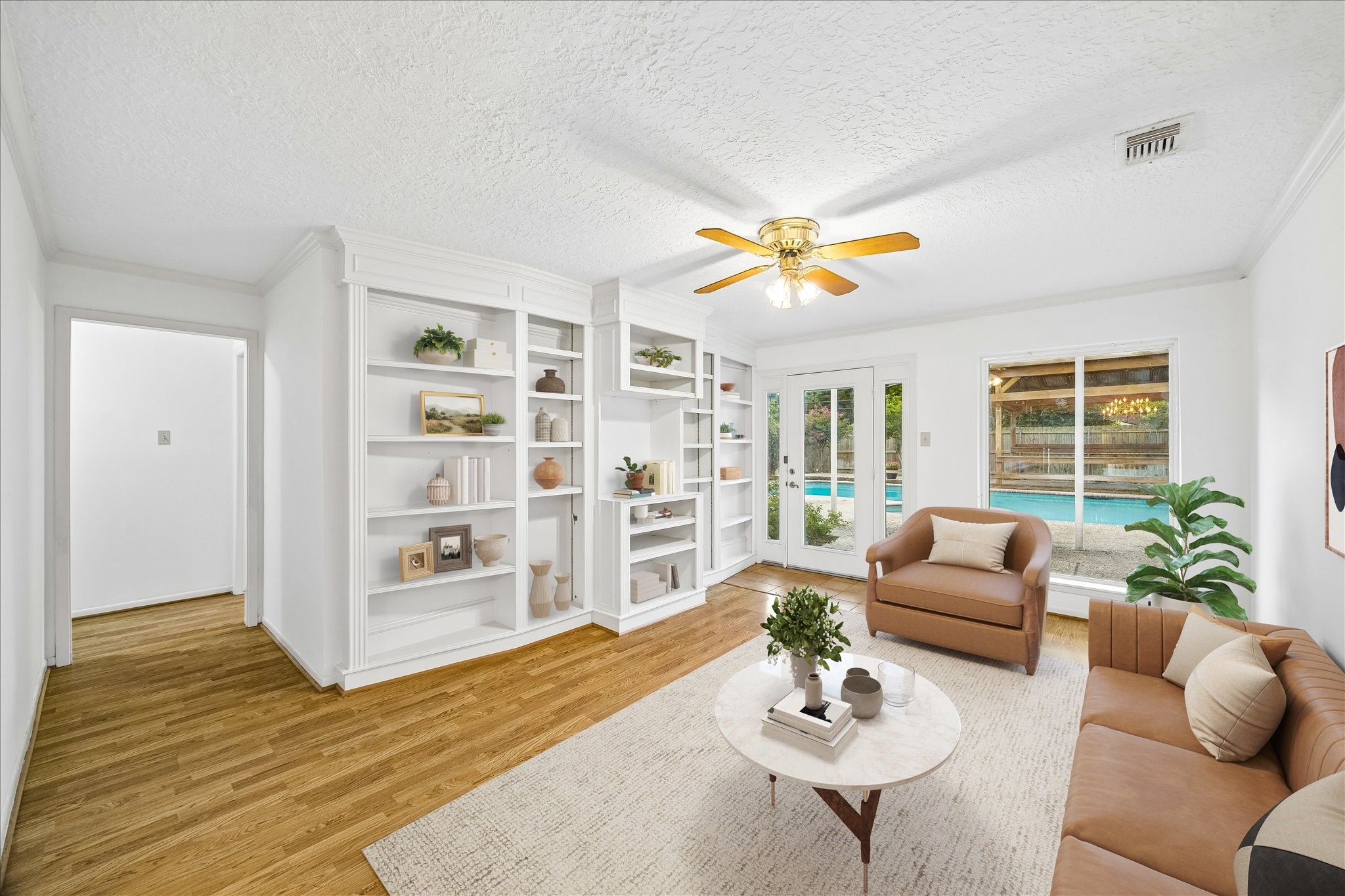 5515 Sylmar Road Houston, TX 77081 - Photo 3 of 28 The family room, overlooking the pool and back yard has lots of natural light. Custom built-ins and cabinetry offer space for an entertainment system. this photo has been virtually staged