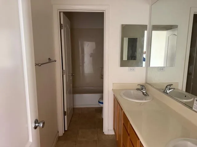 a bathroom with a tub sink and mirror