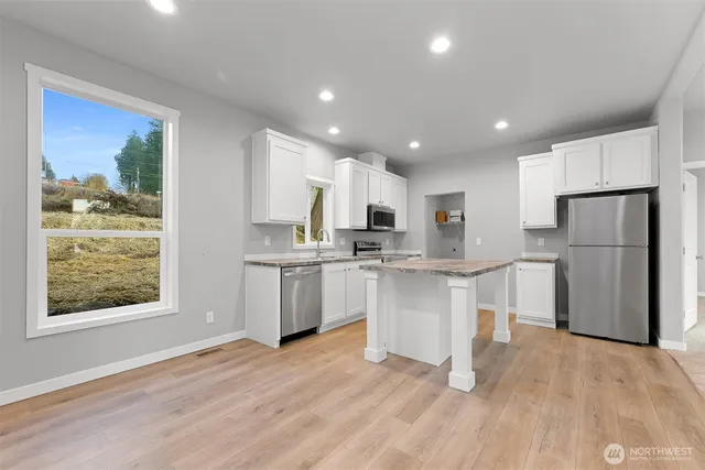 a kitchen with white cabinets and refrigerator