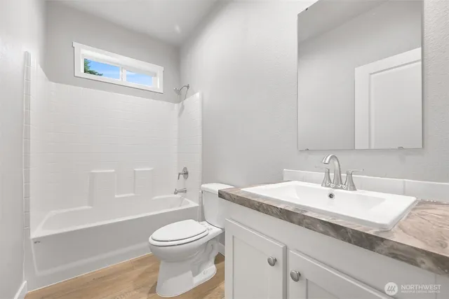 a bathroom with a granite countertop toilet a sink and bathtub