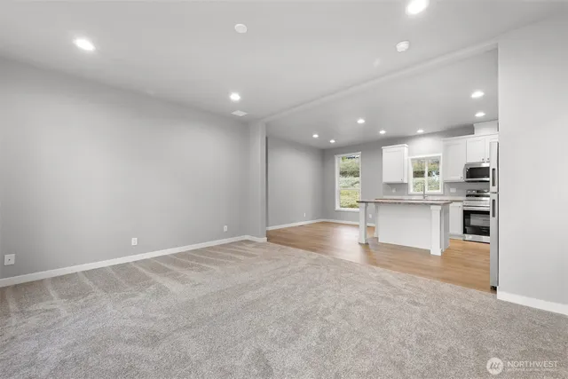a view of kitchen with kitchen island white cabinets and refrigerator