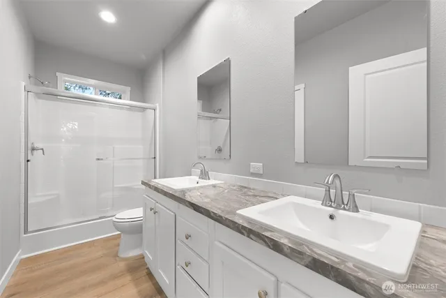 a bathroom with a sink a toilet and shower