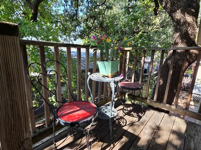 a view of a patio with table and chairs potted plants and large tree