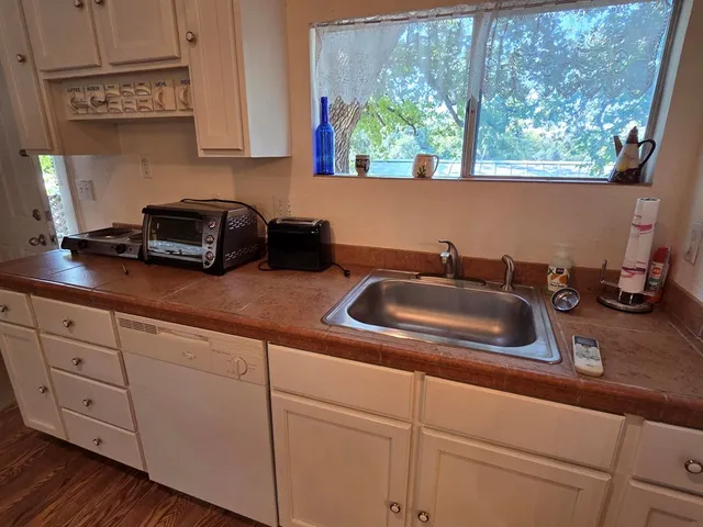 a kitchen with sink a window and cabinets