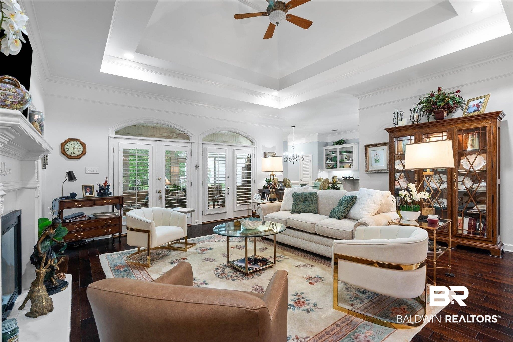 136 Old Mill Road Fairhope, AL 36532 - Photo 12 of 36 Spacious living area featuring dark wood-finish flooring, a white mantel with a fireplace, and a tray ceiling with a ceiling fan