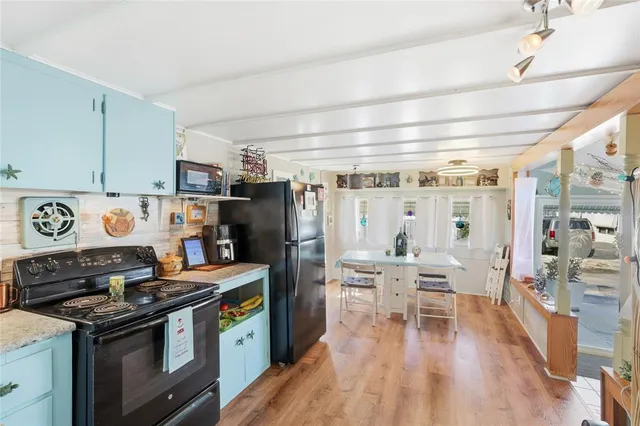 a kitchen with stainless steel appliances a stove a refrigerator and wooden floors