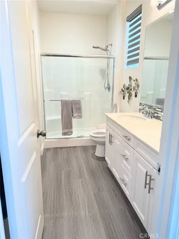 a bathroom with a double vanity sink a toilet and shower