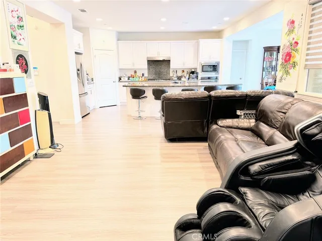 a living room with stainless steel appliances furniture and a kitchen
