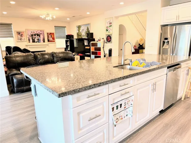 a kitchen with stainless steel appliances granite countertop a sink and a refrigerator
