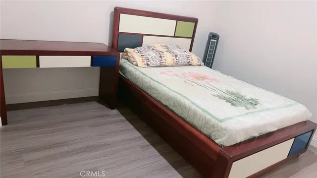 a bed sitting in a bedroom next to a lamp