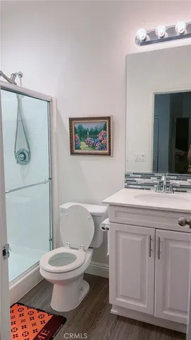 a bathroom with a granite countertop toilet sink and mirror