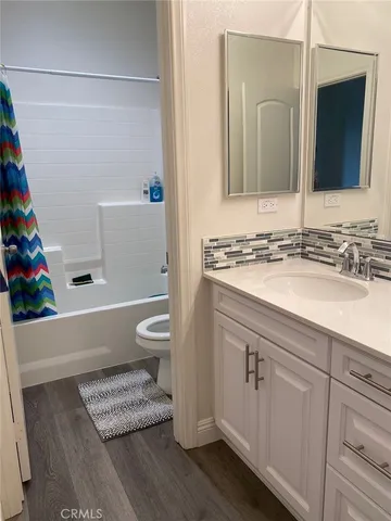 a bathroom with a granite countertop sink a toilet and a mirror