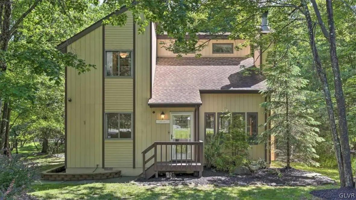 a view of a brick house with a large windows and a yard