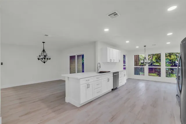 an empty room with mirror and a hallway