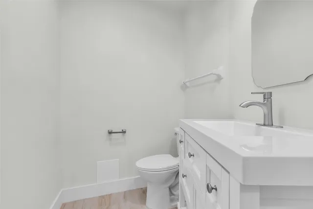 an empty room with wooden floor ceiling fan and windows