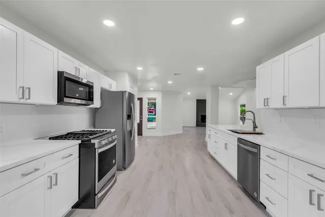 a kitchen with stainless steel appliances granite countertop a refrigerator and a sink