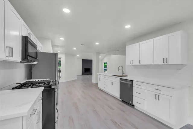 a view of a kitchen with a refrigerator and a stove top oven