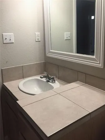 a bathroom with a sink vanity and a mirror