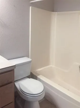 a white toilet sitting next to a bath tub