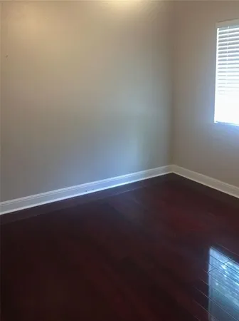 a view of a small space with wooden floor and a window