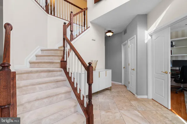 a view of staircase with lots of frames and a rug
