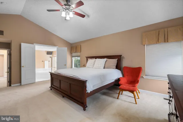 a spacious bedroom with a bed and a chandelier