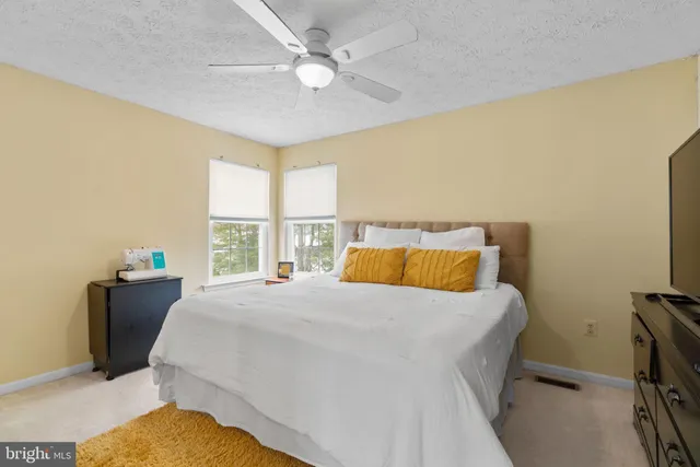 a bedroom with a bed dresser and a window