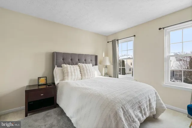 a large bed sitting in a bedroom next to a window