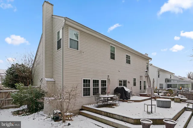 a view of a patio with couches table and chairs under an umbrella